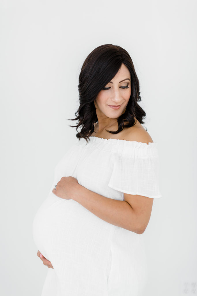 6 Things to Do When You Find Out You are Pregnant. Pregnant mom during studio maternity session. White Studio. St Louis Maternity Session. White Maternity Dress. 