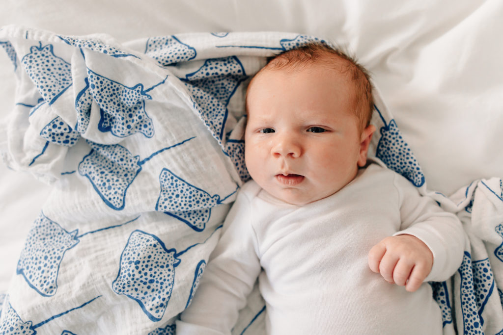 Baby boy laying on swaddle during an in home lifestyle newborn session by kelly laramore photography. Located in Kirkwood, missouri. 