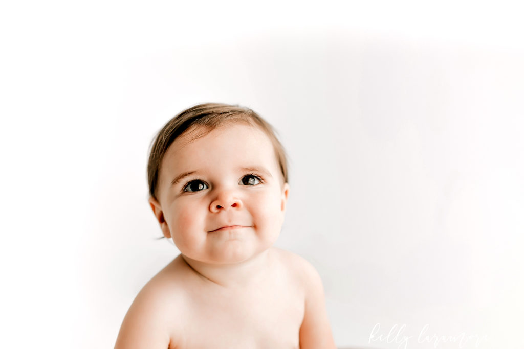 A simple modern classic baby milestone session by st louis baby photographer in an all white studio.