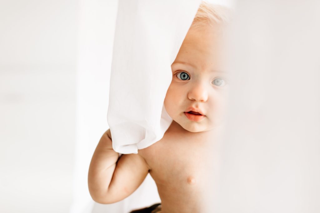 Baby playing with curtain