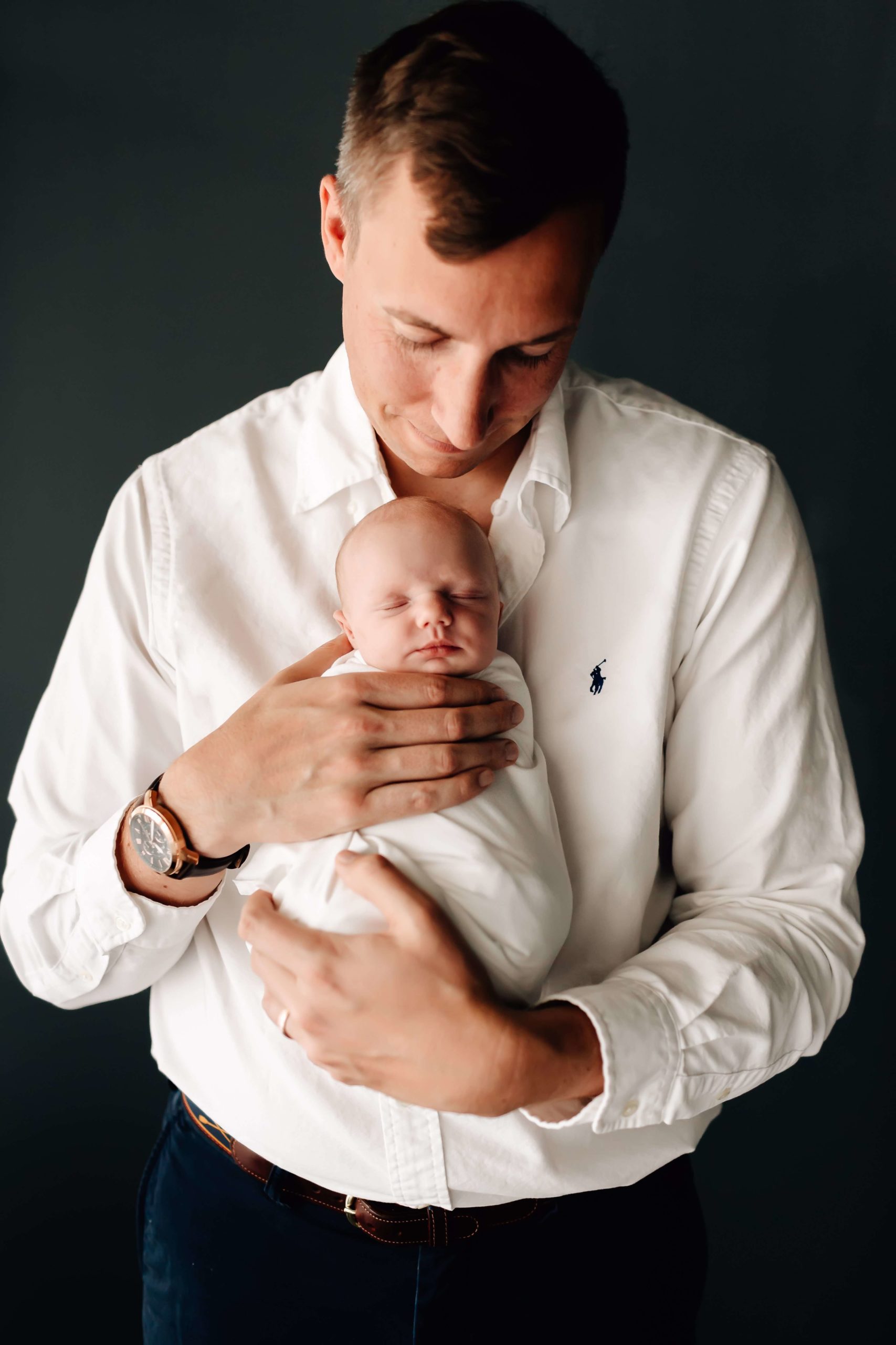 Dad in white dress shirt, dad holding newborn girl, dad wearing watch, smiling dad at studio newborn session