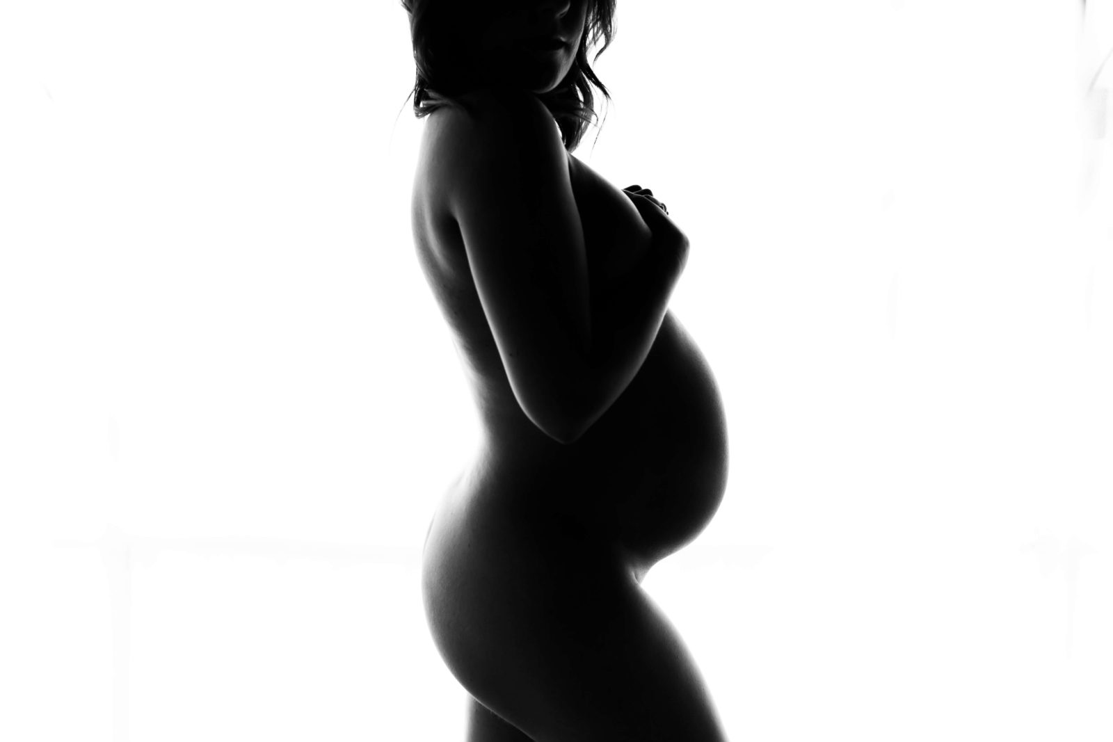 bare belly session with pregnant woman in nude silhouette in black and white image