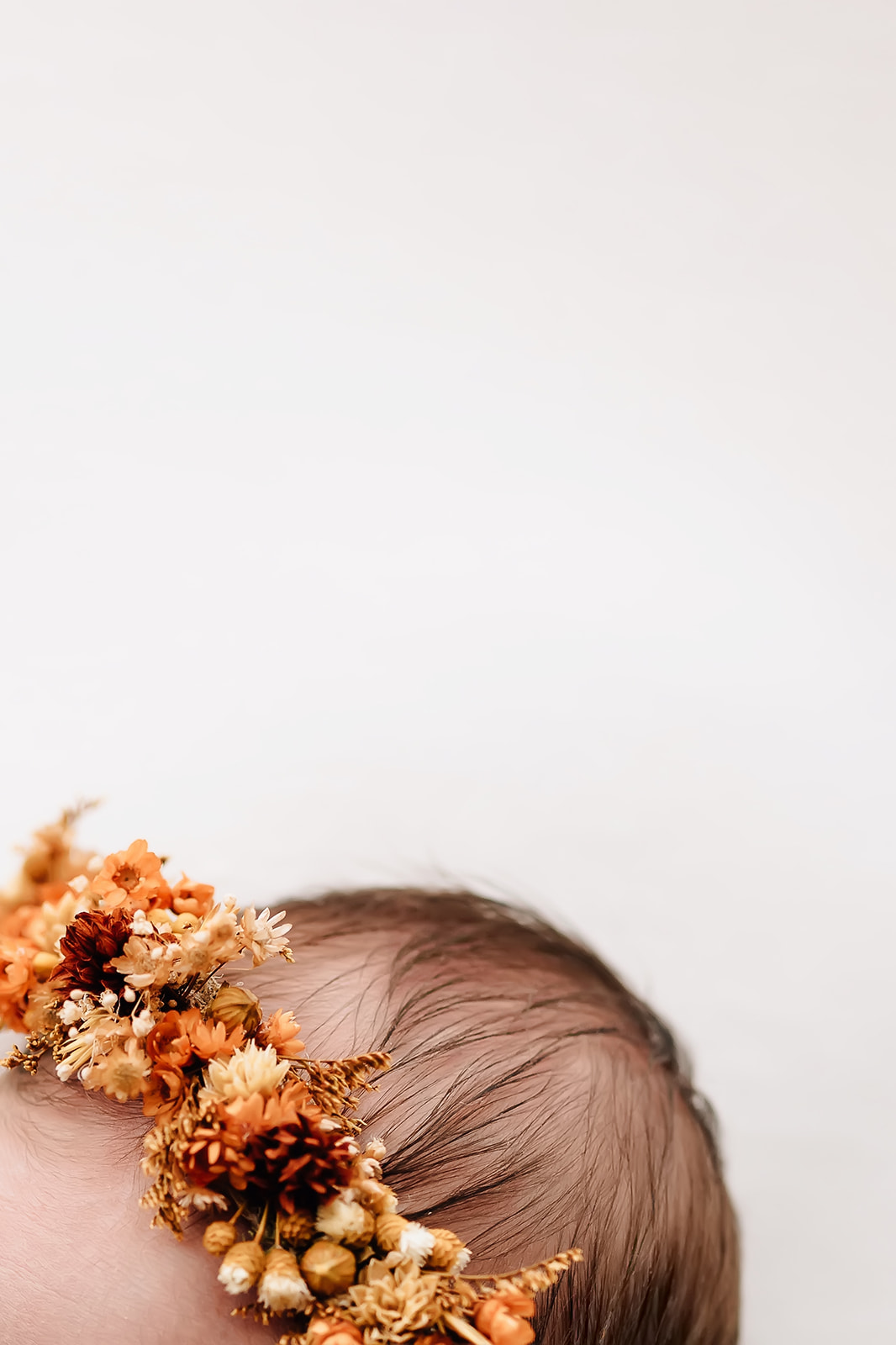 Details of a newborn baby head in a floral headband St Louis prenatal yoga