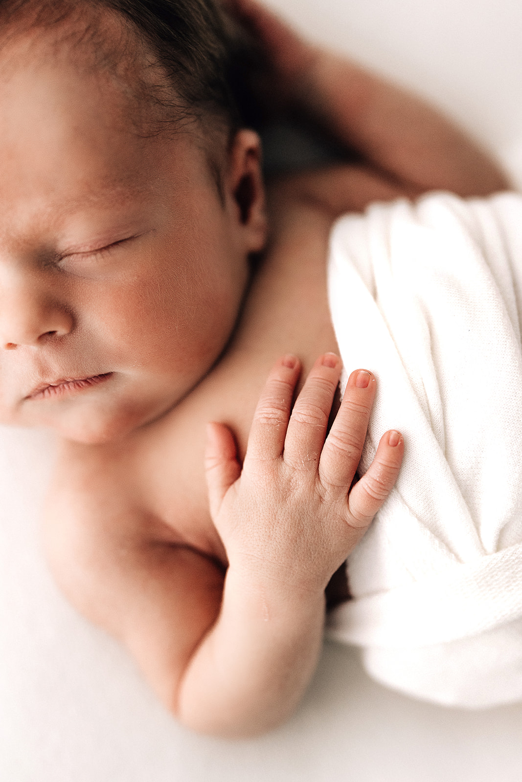 Details of a sleeping newborn with a hand on its chest Doulas of Greater St Louis