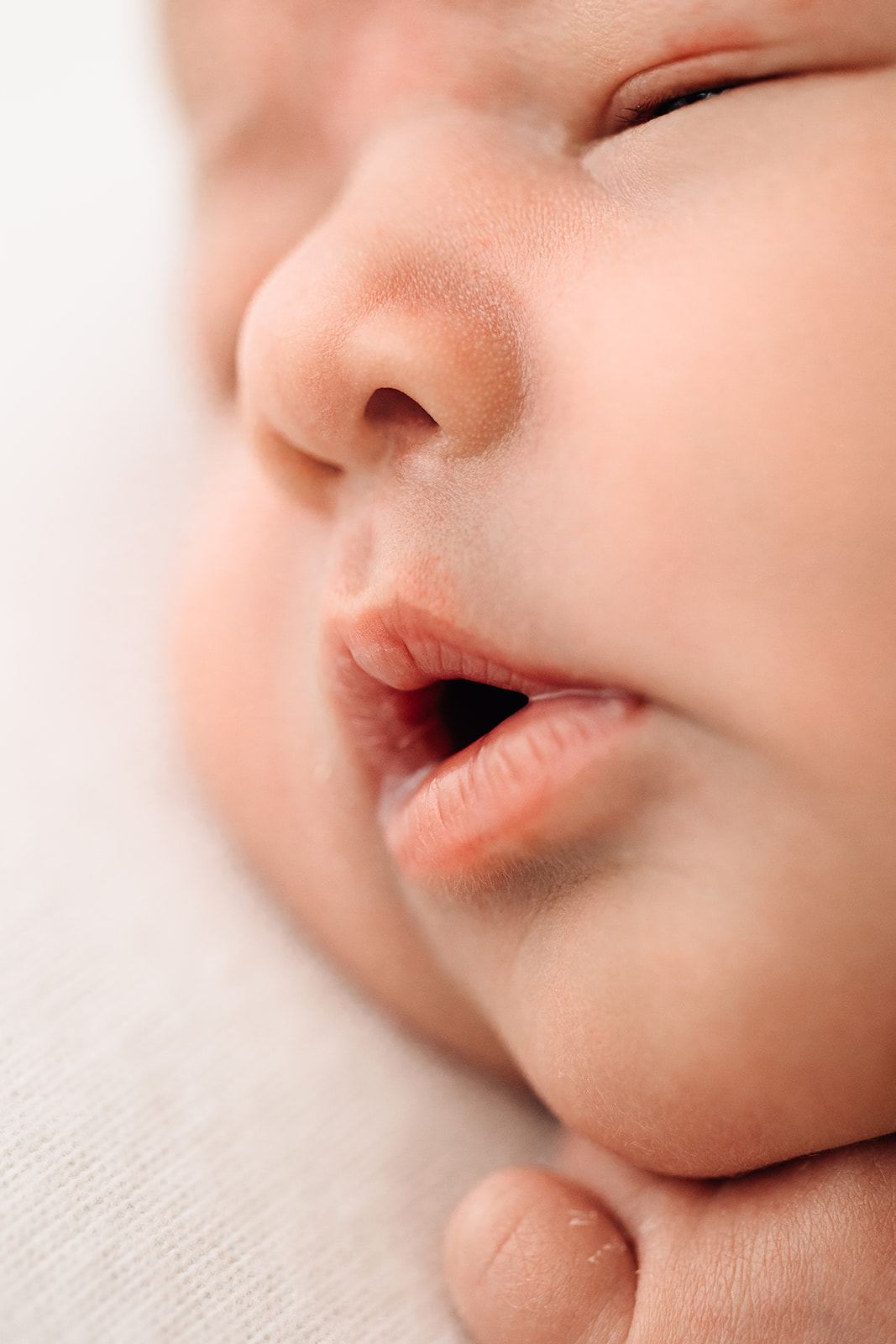 A sleeping newborn baby's face with mouth open after IVF St Louis